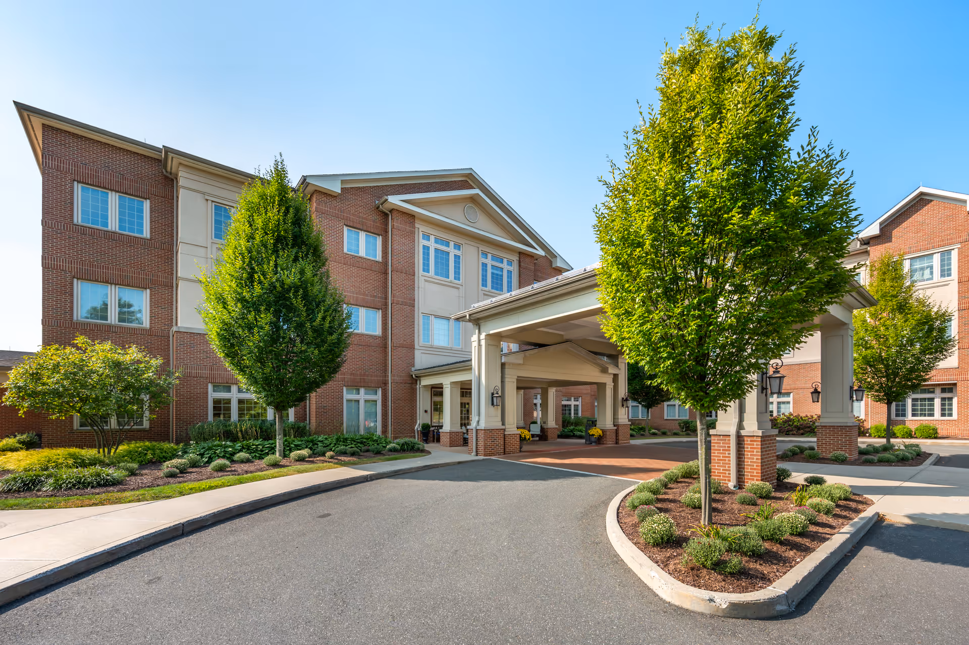 Brookdale Chatfield exterior: brick building with a covered entrance and manicured landscaping.