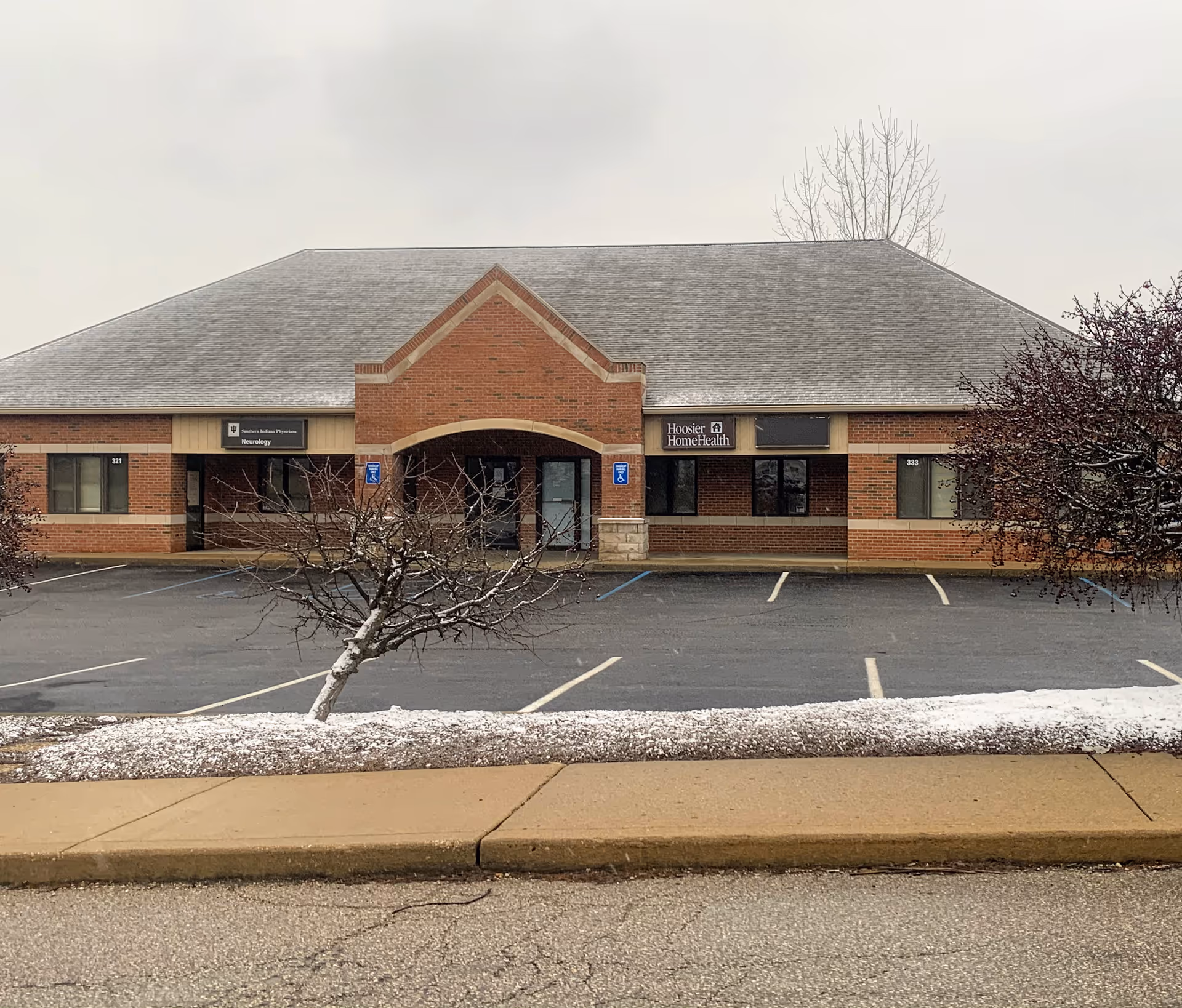 Brick building with Hoosier Home Health sign and a parking lot.
