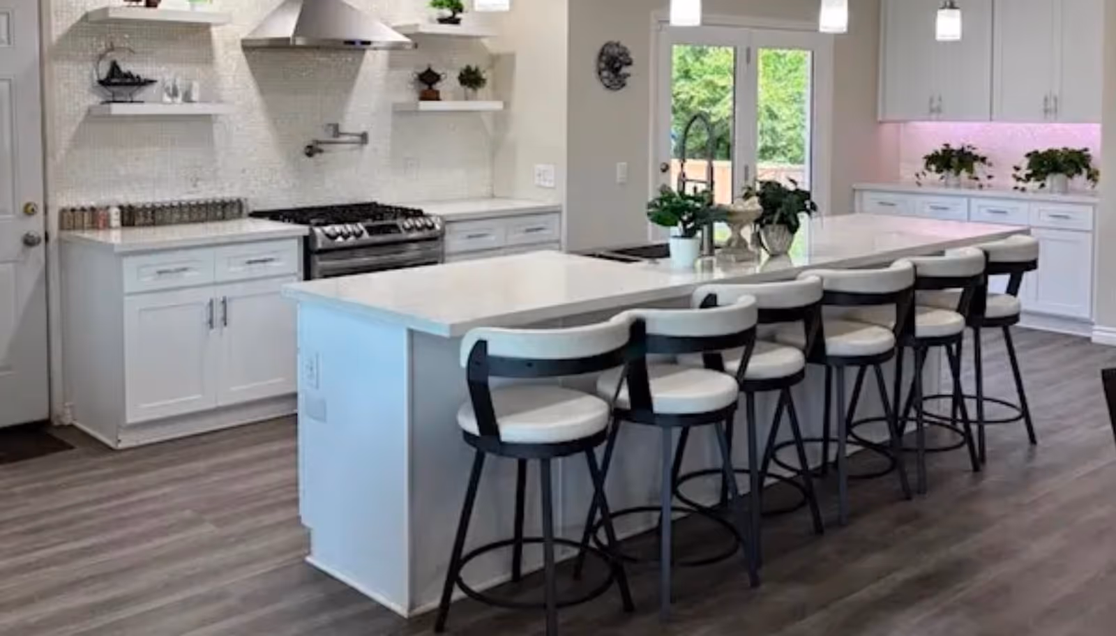Bright modern kitchen with an island and white stools in a senior living facility