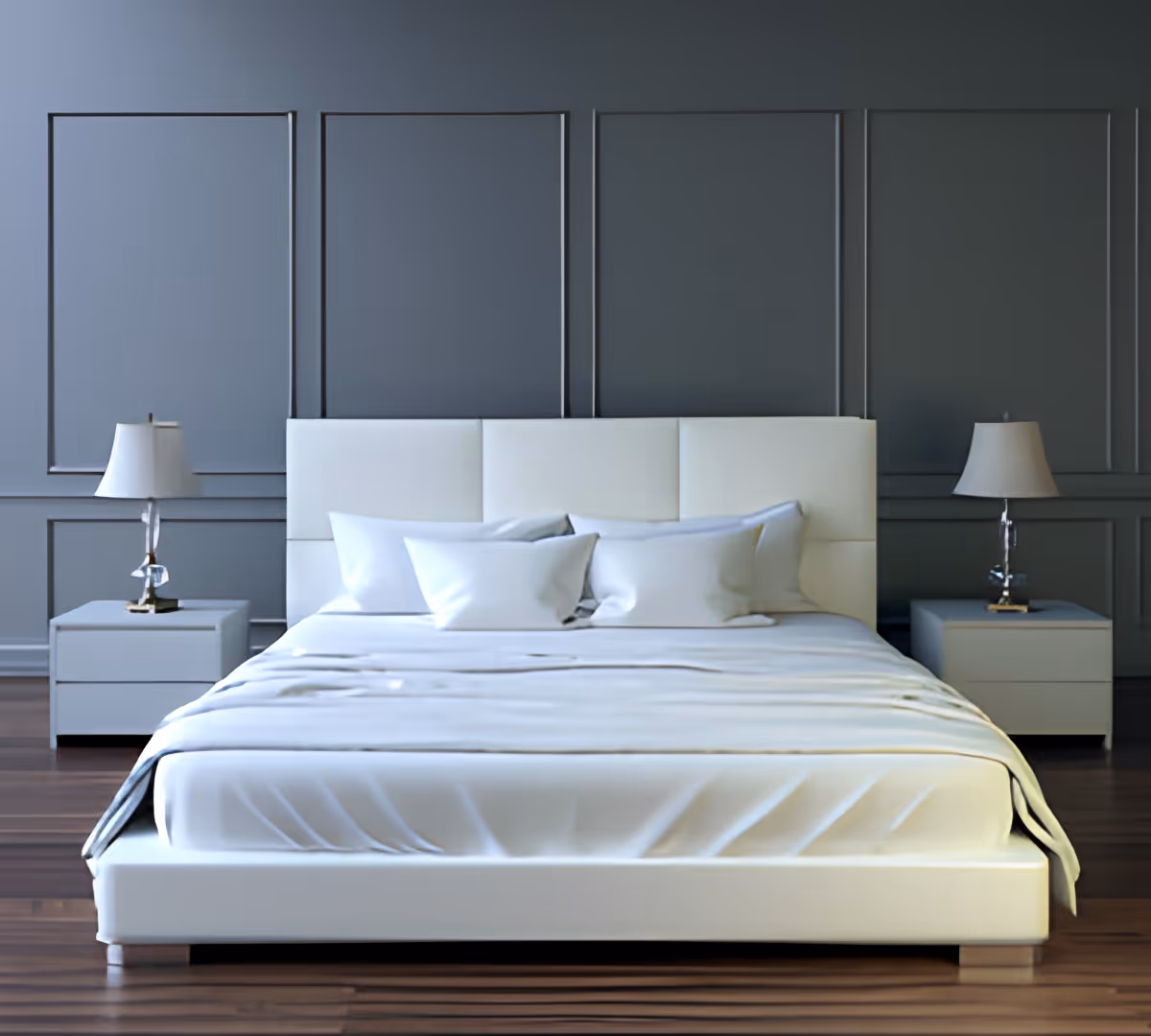 Minimalist modern bedroom with a low white bed, pillows, two bedside tables and lamps against a dark paneled wall.