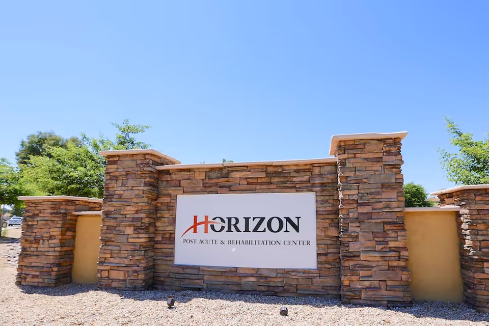 Stone entrance sign for Horizon Post Acute & Rehabilitation Center against a clear blue sky.