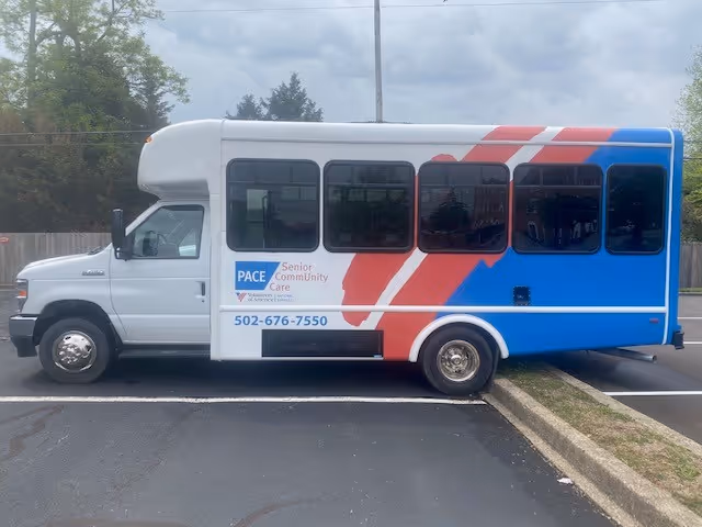 White shuttle bus with red-blue graphics branded PACE parked in a parking lot.