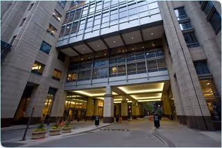 Modern hospital exterior with glass entrance and illuminated drop-off canopy at Northwestern Memorial.