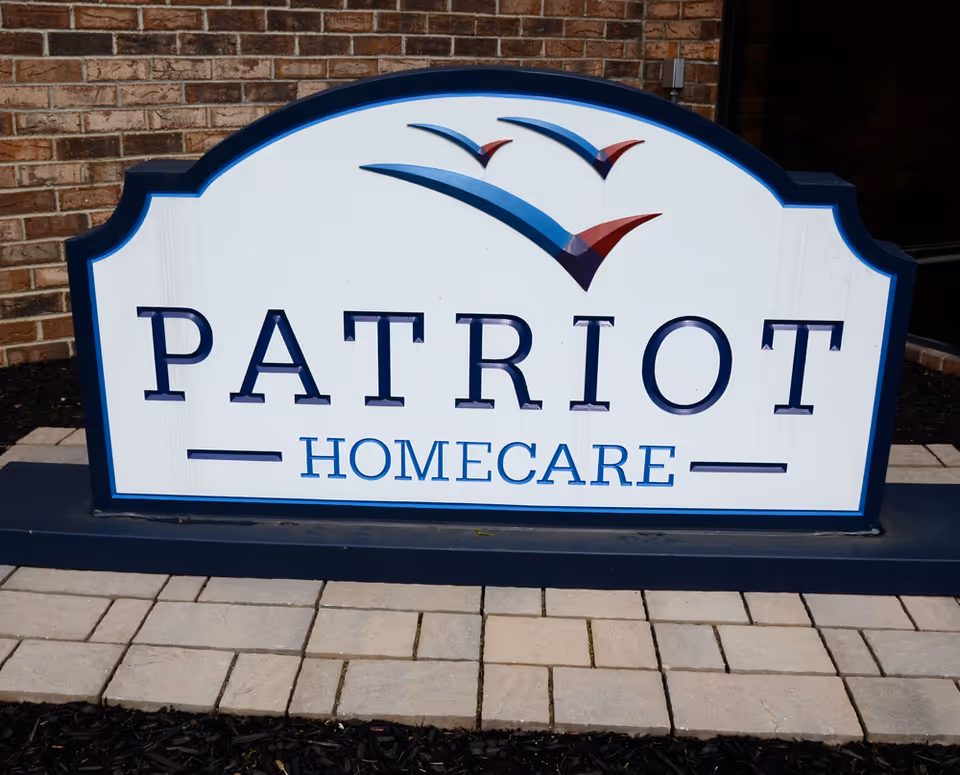 Patriot HomeCare sign mounted on brick exterior by walkway