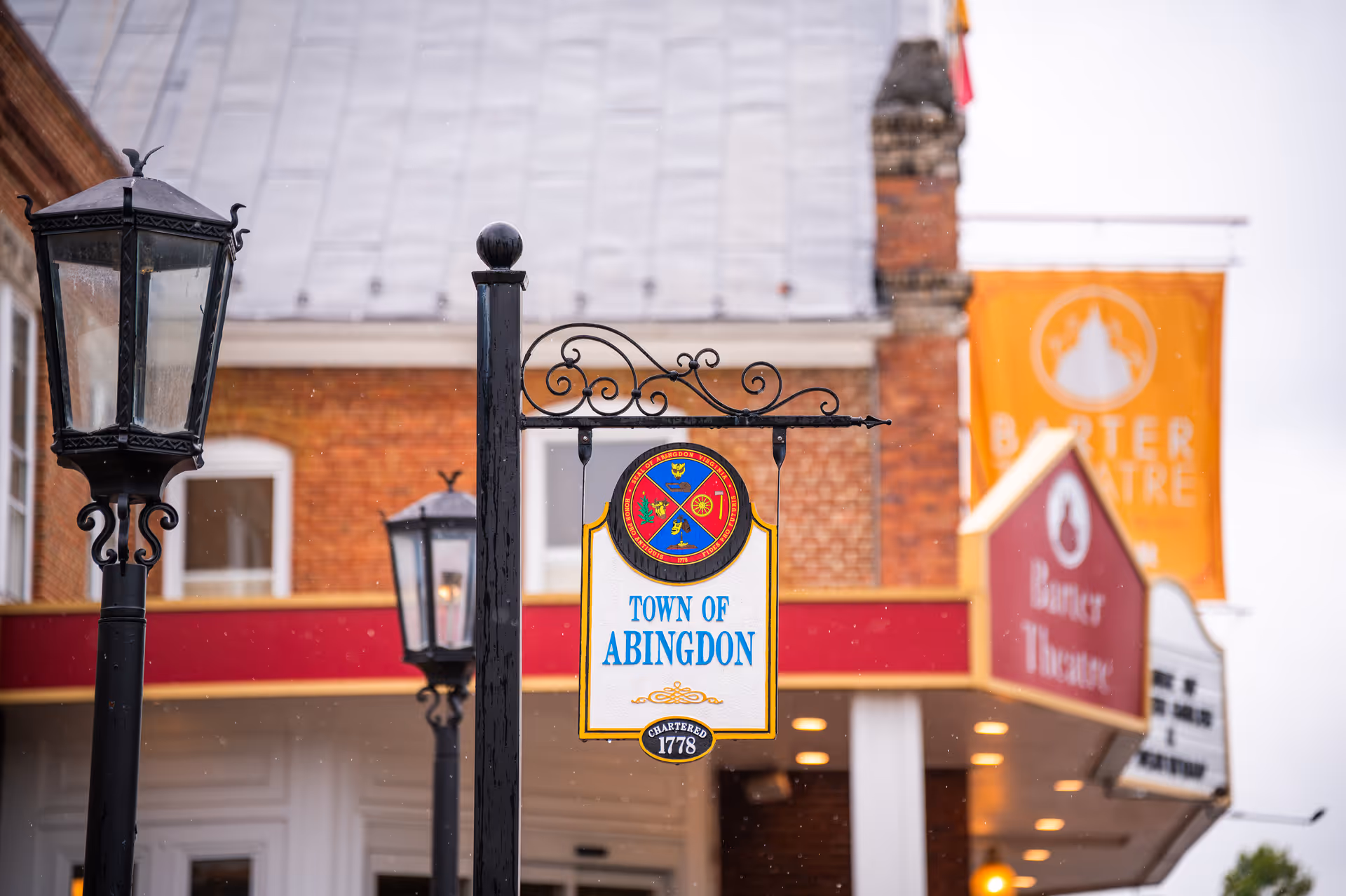 Street view with Abingdon town sign, lampposts, and Barter Theatre storefront.