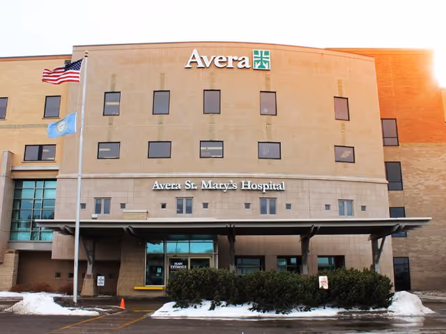 Front exterior of Avera St. Mary's Hospital with flags and a sheltered entrance.