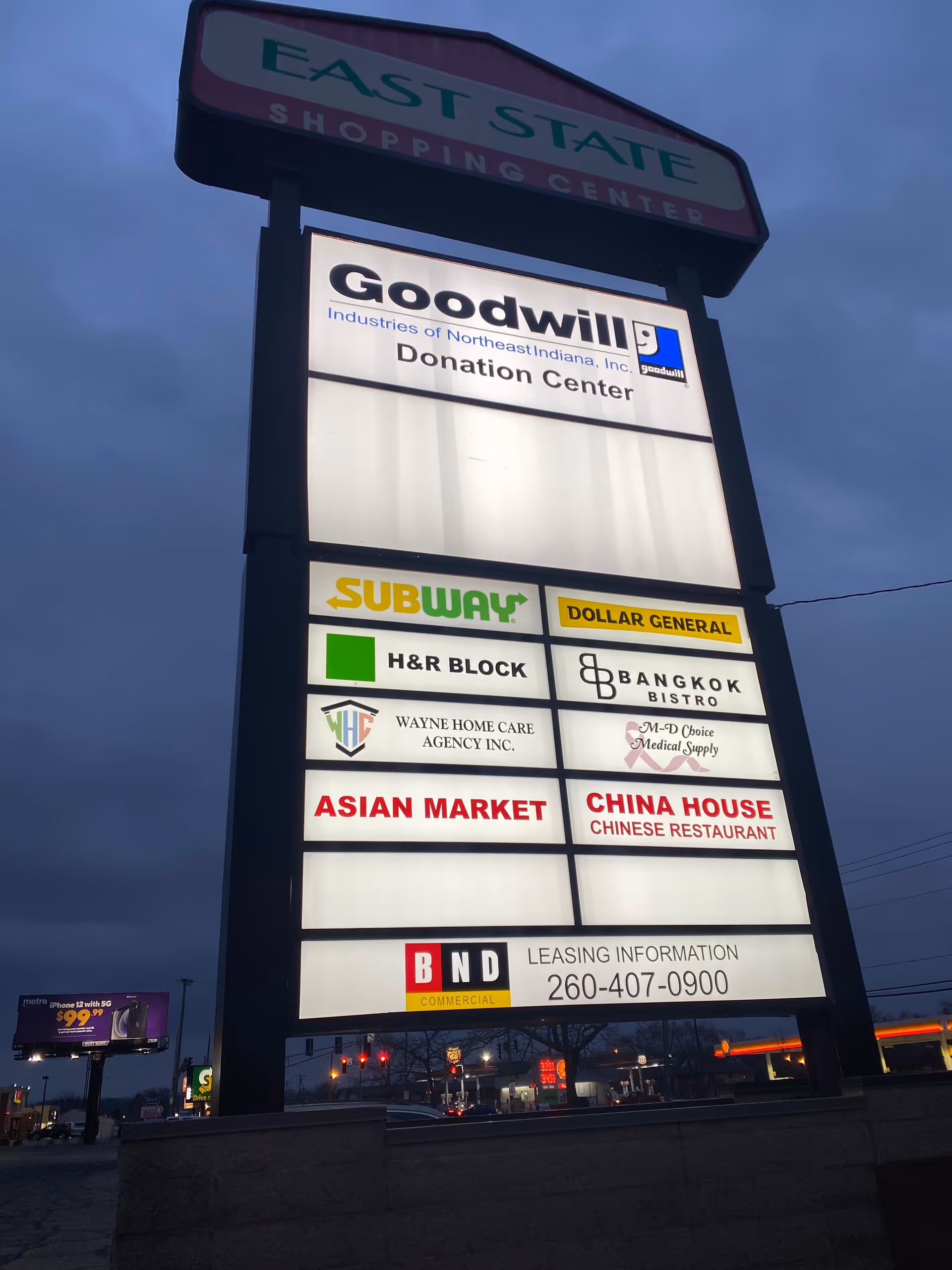 Tall outdoor sign displays multiple storefronts, including Goodwill and Subway.