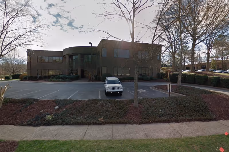 Front view of FirstLight Home Care of Apex building with parking lot and trees