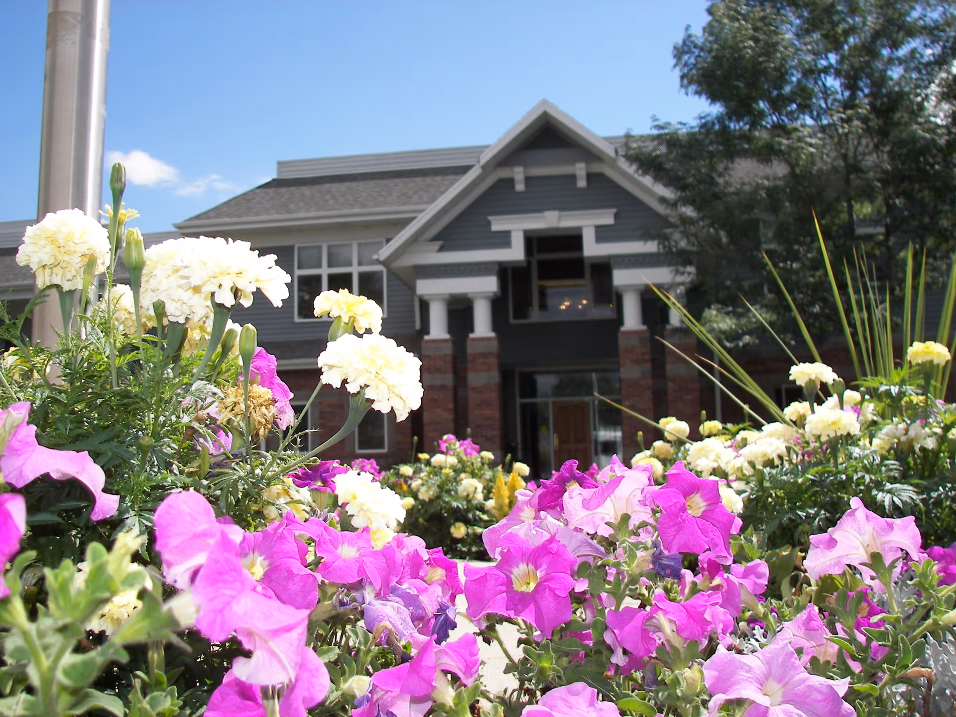 Front view of Worthington senior living building with colorful flowers in foreground.