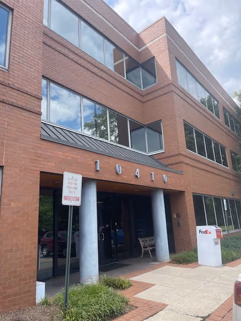 Brick senior living facility exterior with glass entrance, large windows, and a FedEx drop box.