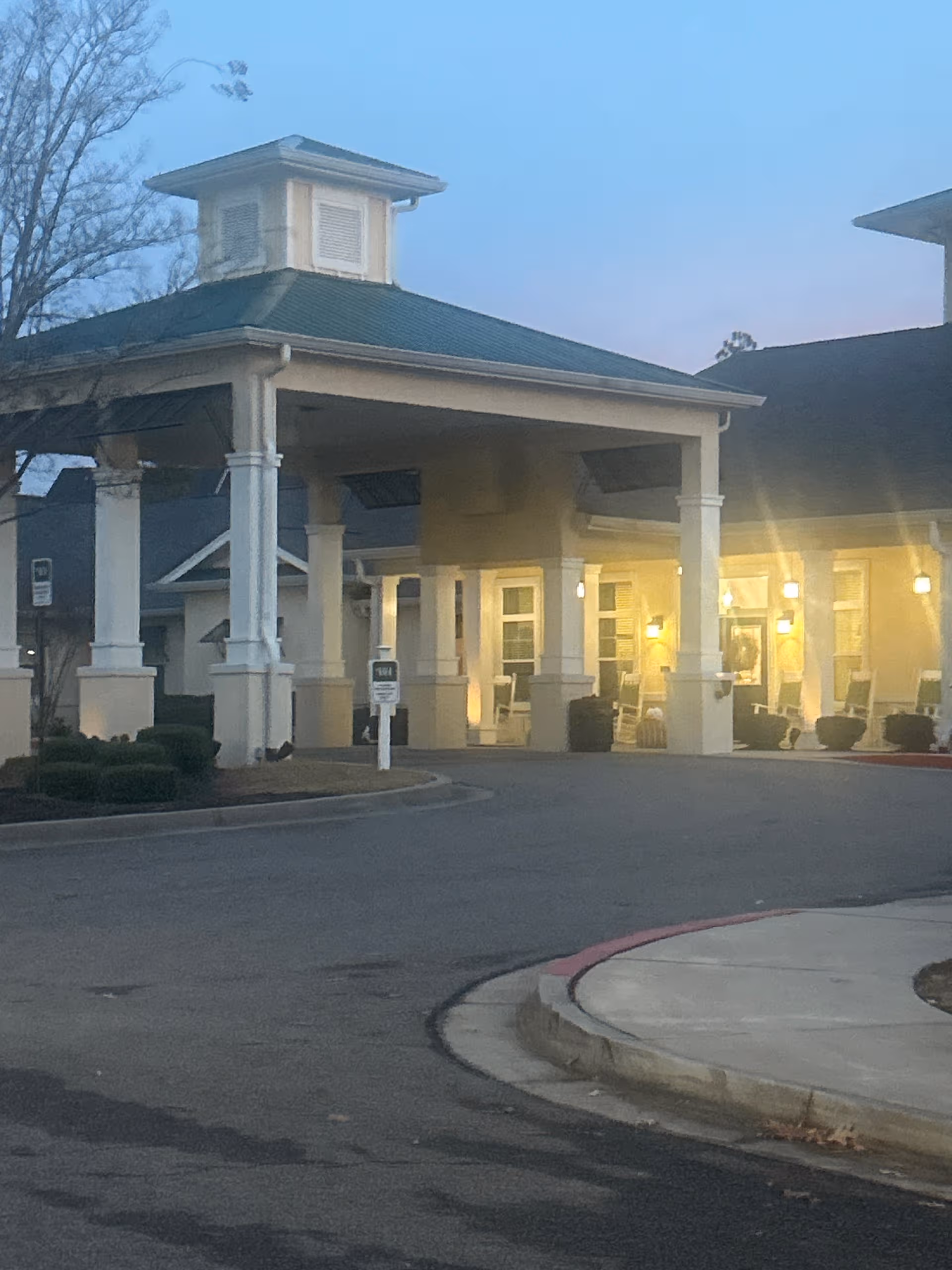 Exterior view of Barclay House of Augusta entrance with covered drop-off and illuminated porch.