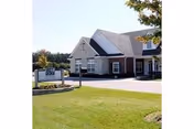Exterior view of The Palms at Florence facility with manicured lawn and sign.