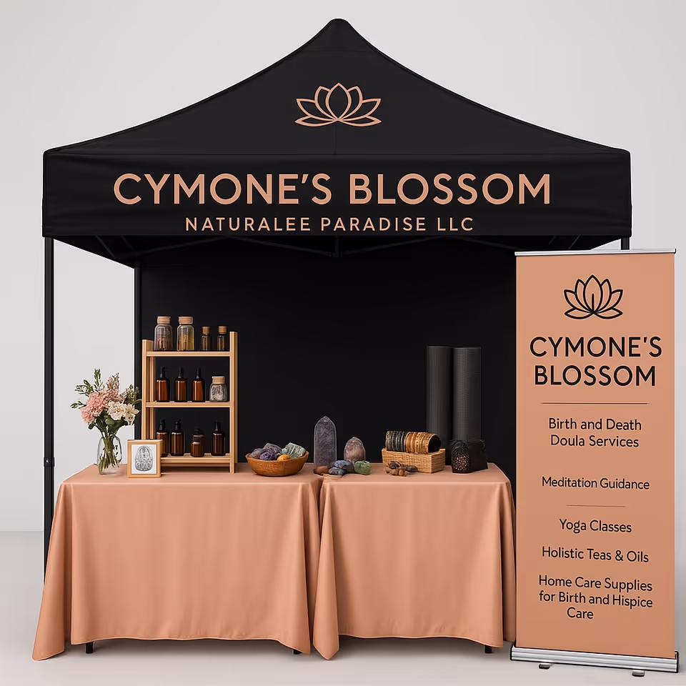A black canopy booth labeled Cymone's Blossom with peach-covered tables and product displays.