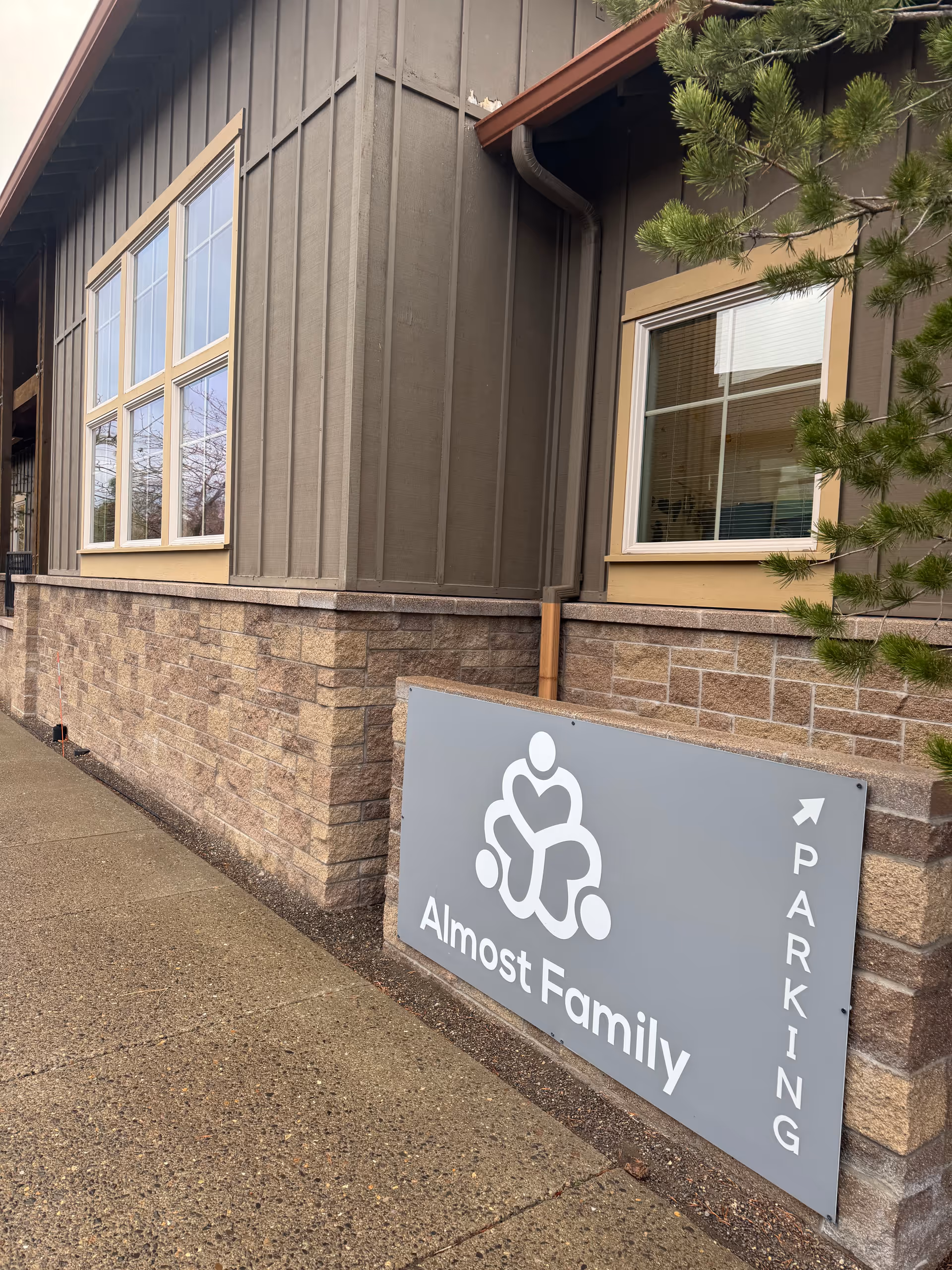 Exterior view of Almost Family facility with sign near the entrance.