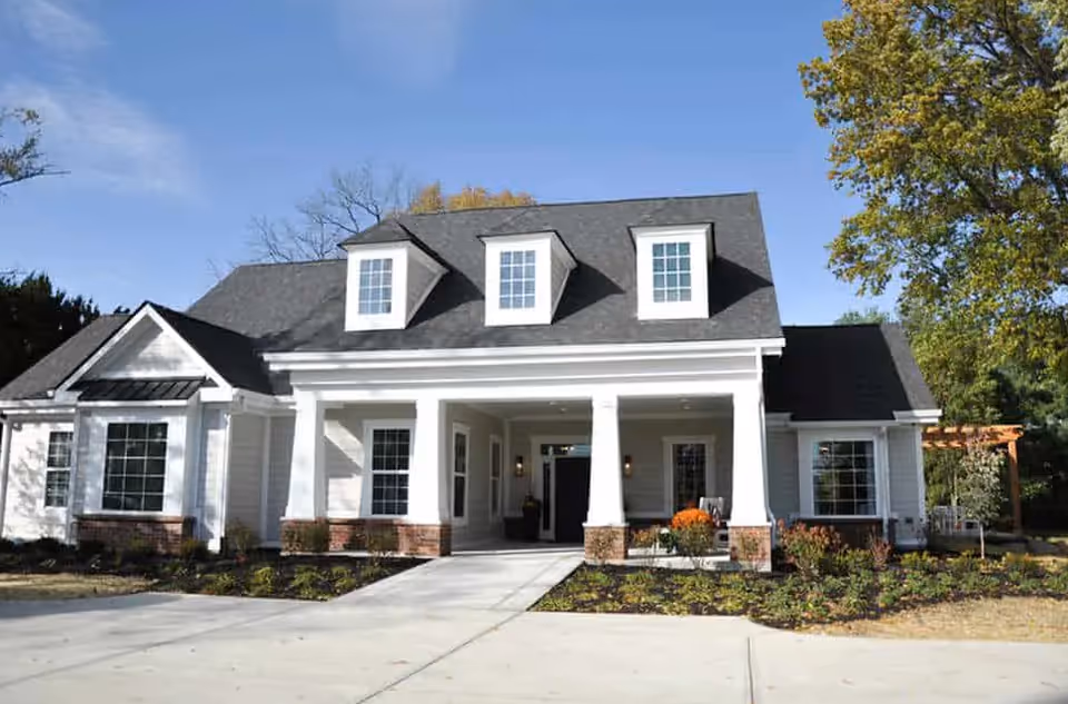 Front exterior of Story Cottage Living, a white cottage-style senior living facility with columns.