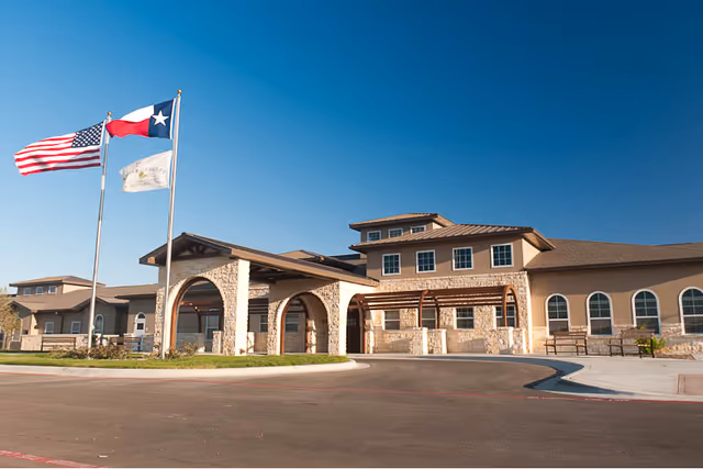 Exterior view of Stoney Brook of Hewitt entrance with arches and flagpoles.