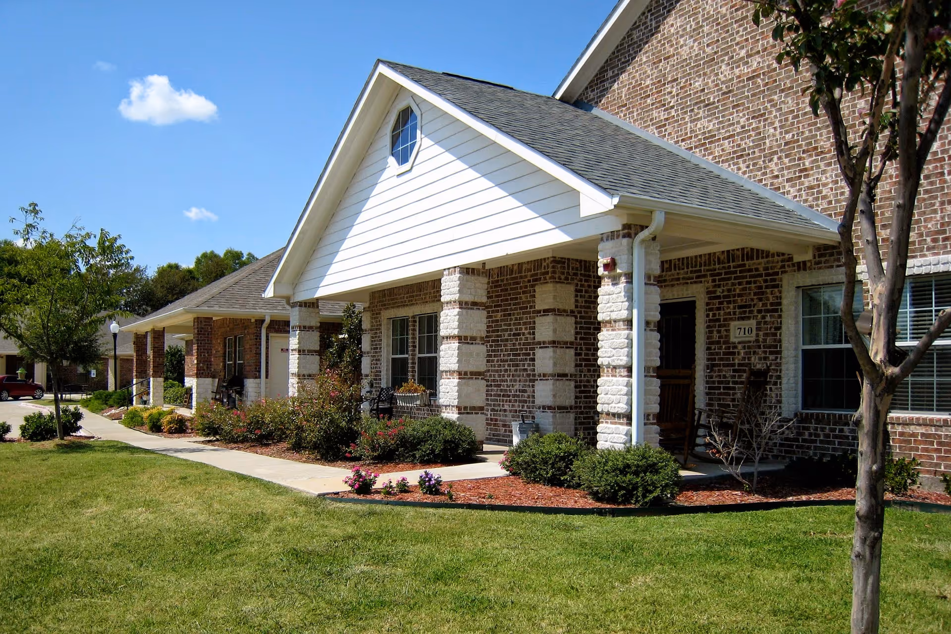 Exterior view of Mustang Creek Estates Allen entry building with lawn and walkway