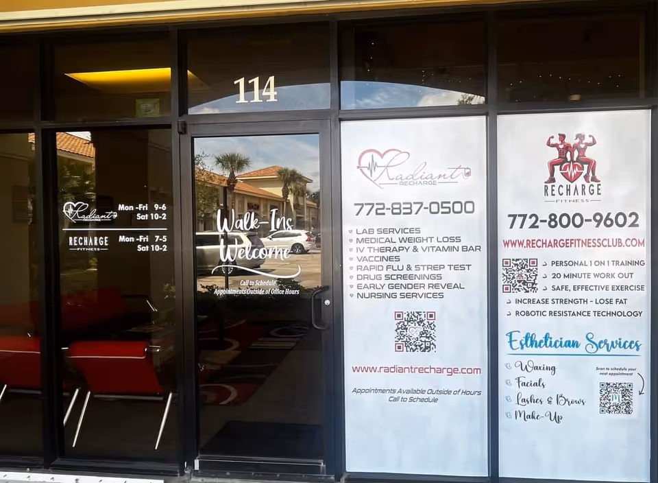 Lobby entrance with glass doors, seating, and large posters advertising services.