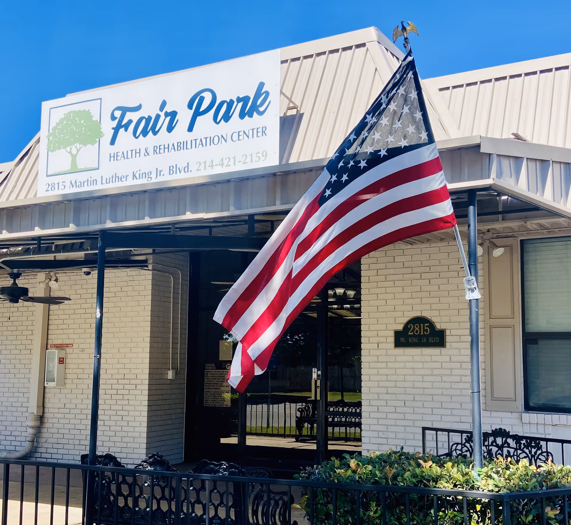 Exterior view of Fair Park Health & Rehabilitation Center with an American flag.