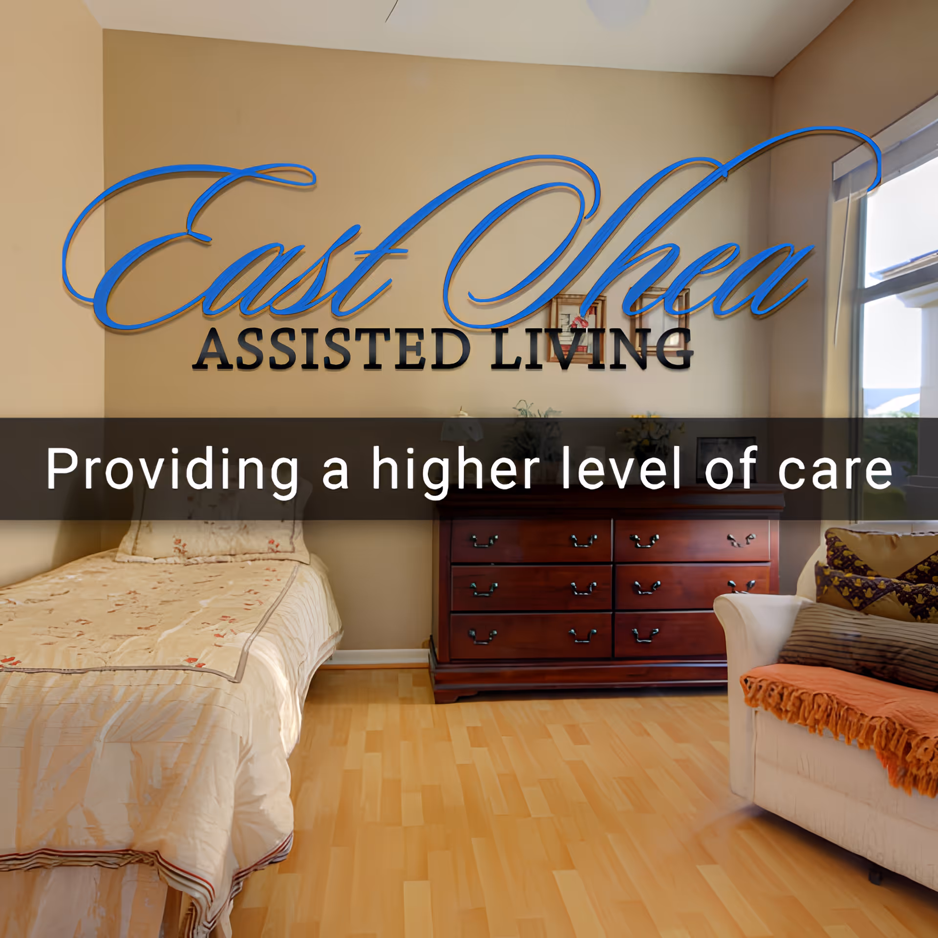 A cozy assisted living room with a single bed covered in a beige bedspread, a wooden dresser with drawers, and a cushioned armchair with pillows and an orange throw. There is a window letting in natural light.
