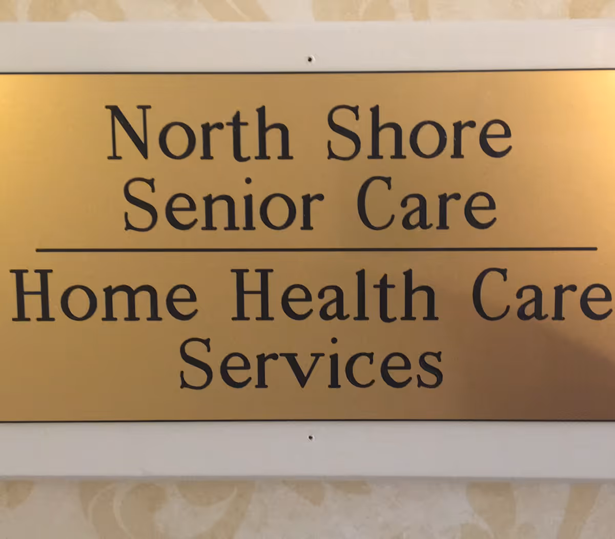 A gold plaque sign displaying North Shore Senior Care and Home Health Care Services.
