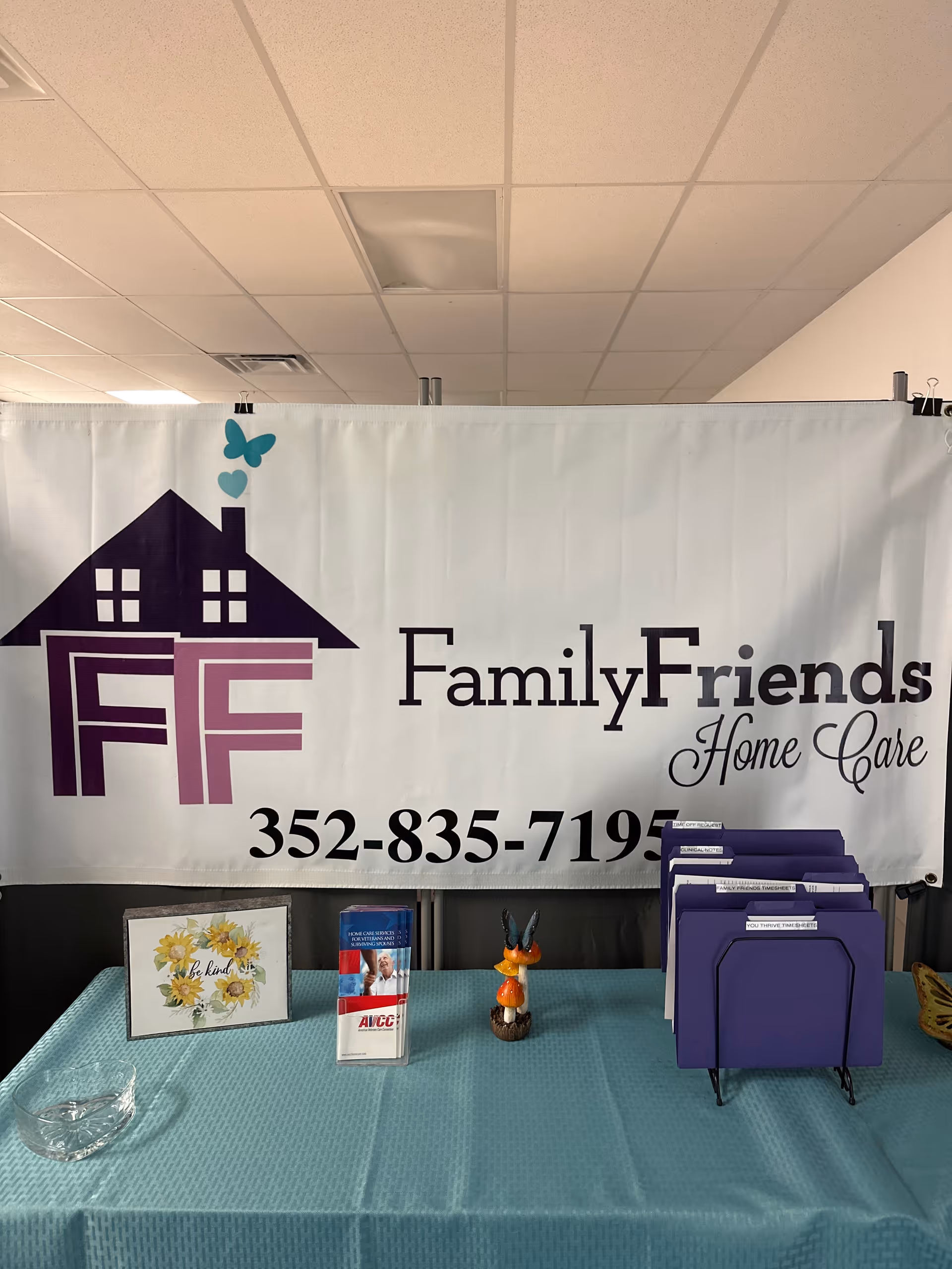 Indoor reception area featuring a Family & Friends Home Care banner over a turquoise table.