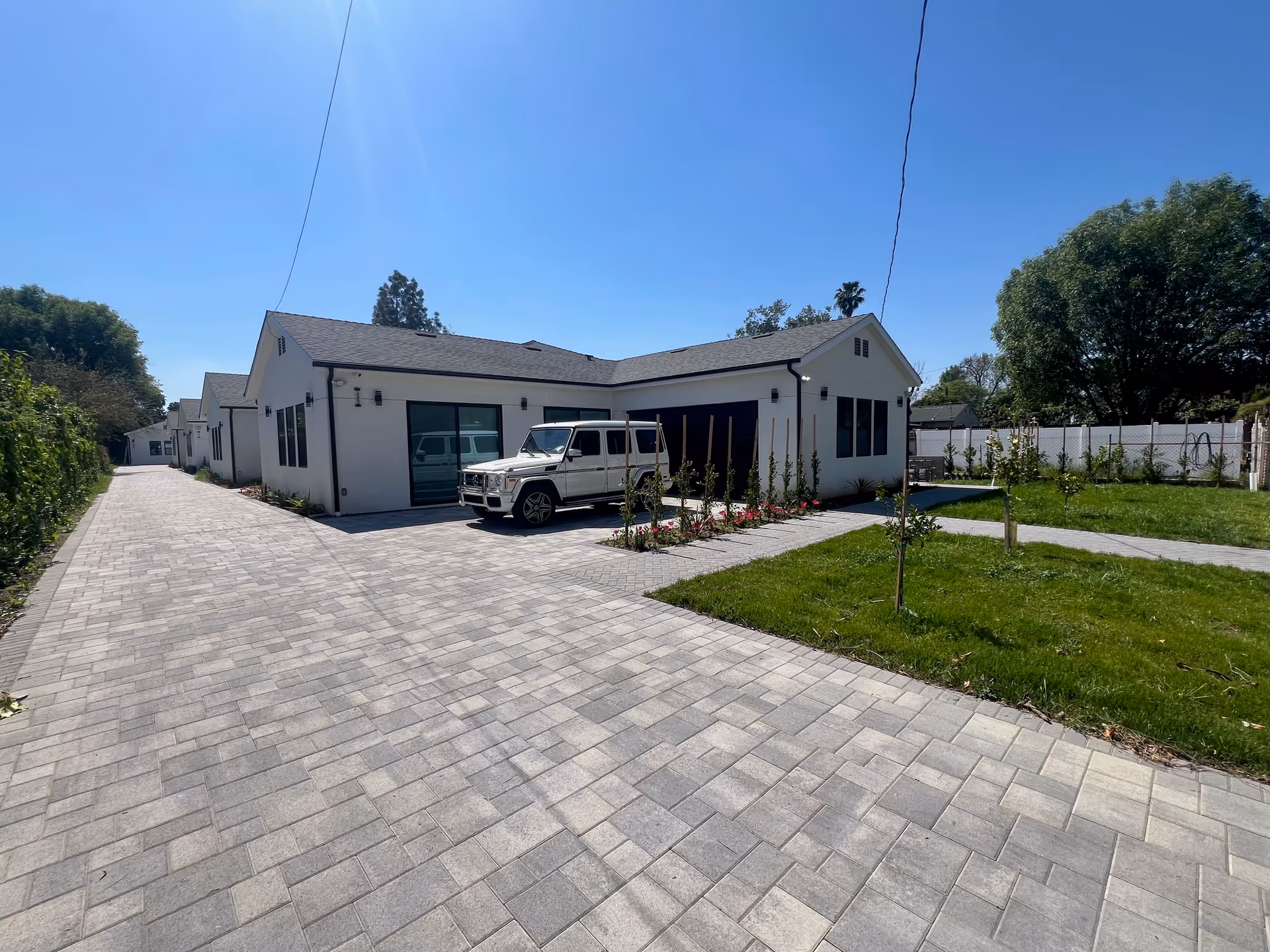 Single-story assisted living facility exterior with a paved driveway, lawn, and parked vehicle.
