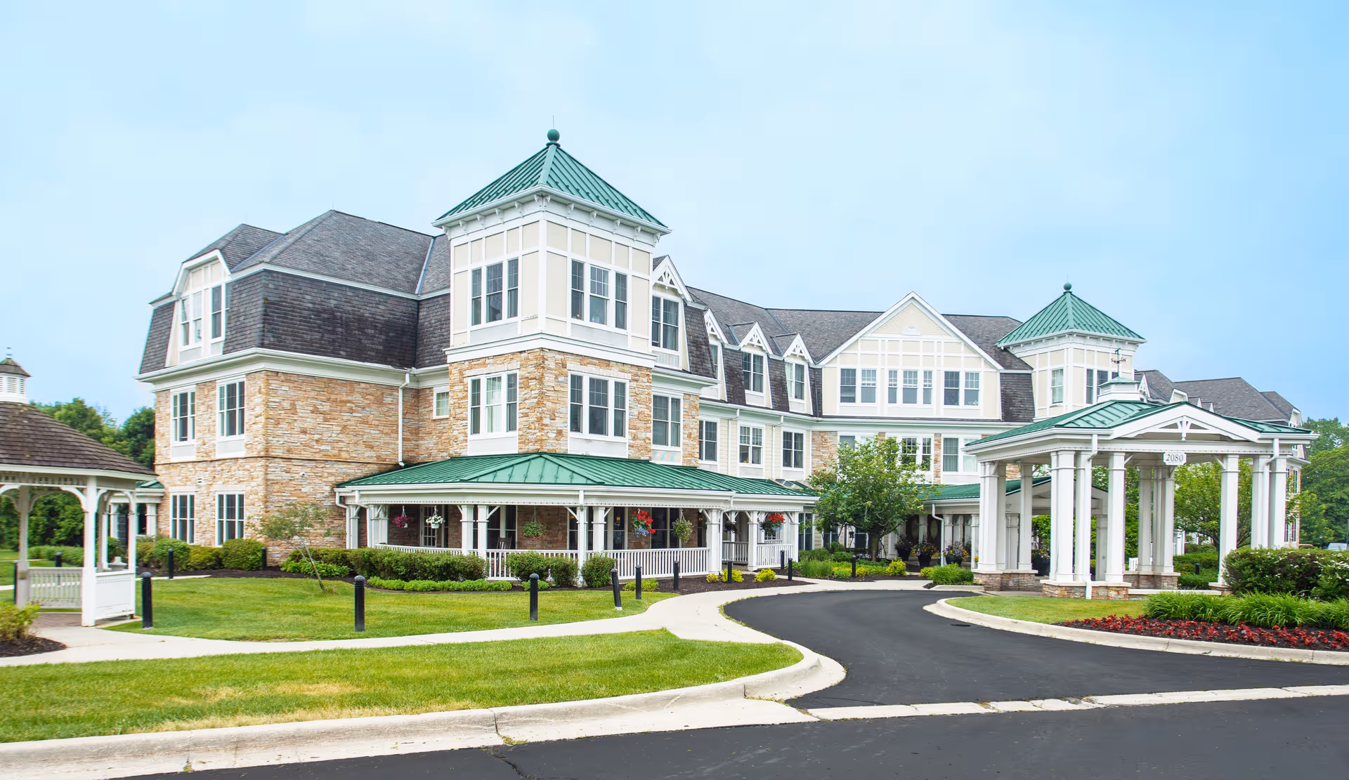Front view of The Bradford Senior Living, a building with green roofs and a curved driveway.