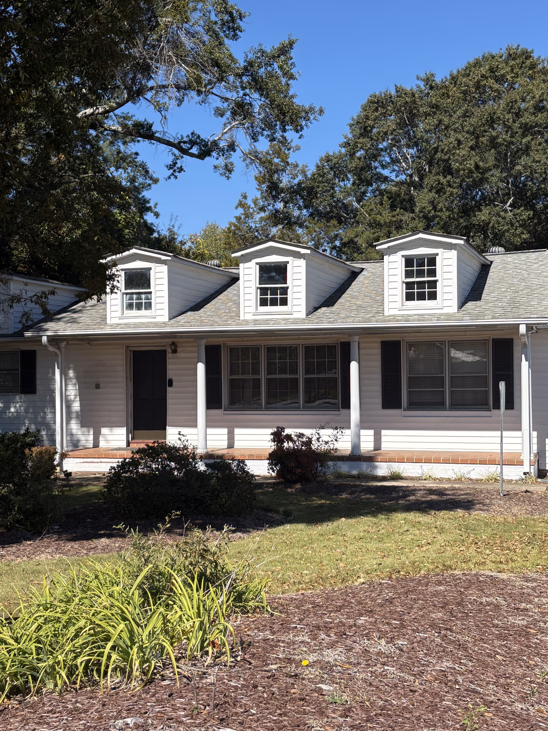 Front view of a single-story senior living facility with dormer windows and a porch.