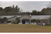 Exterior view of a single-story senior living facility with a parking lot.