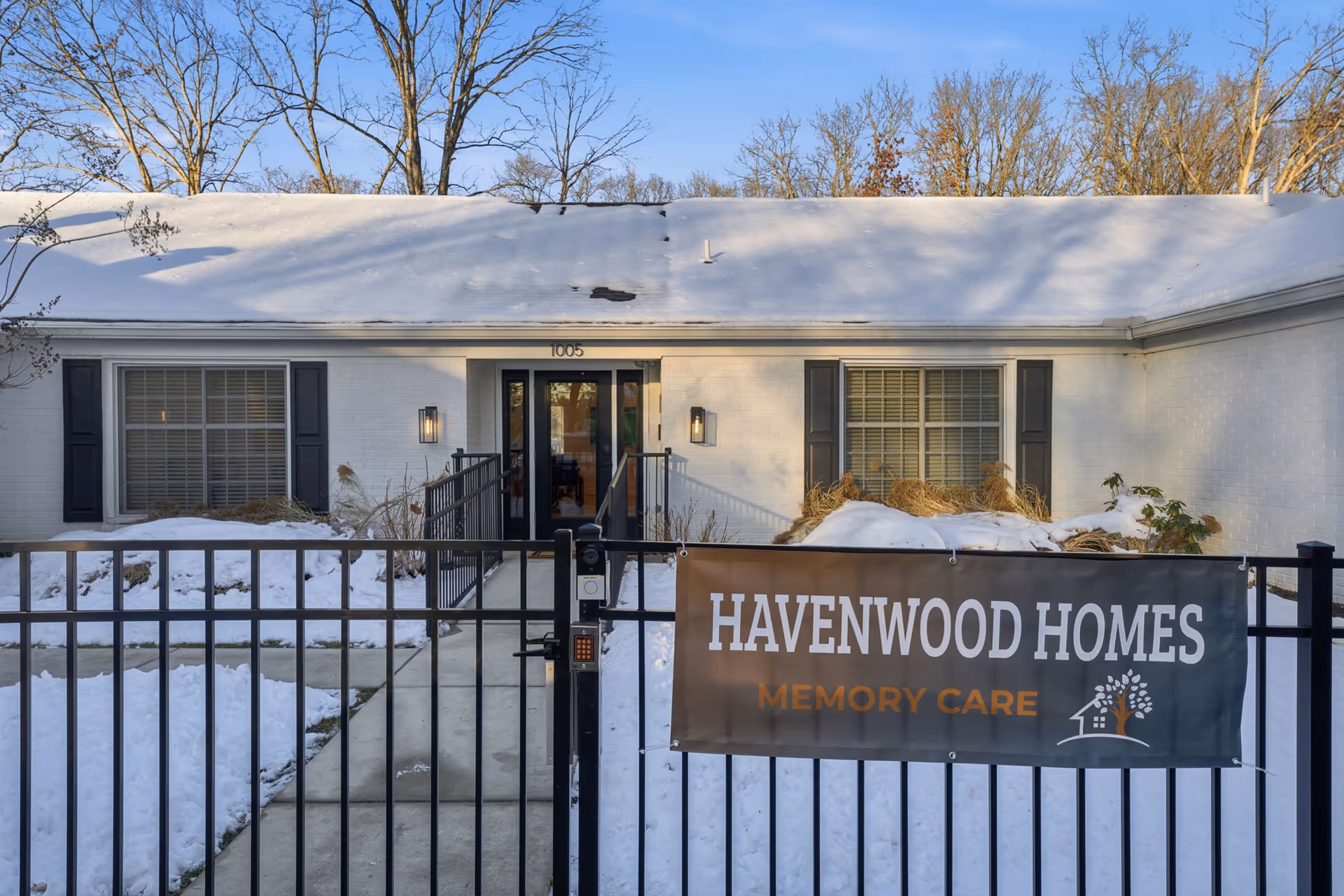 Snow covers front yard; Havenwood Homes entrance, gate, and memory care banner.