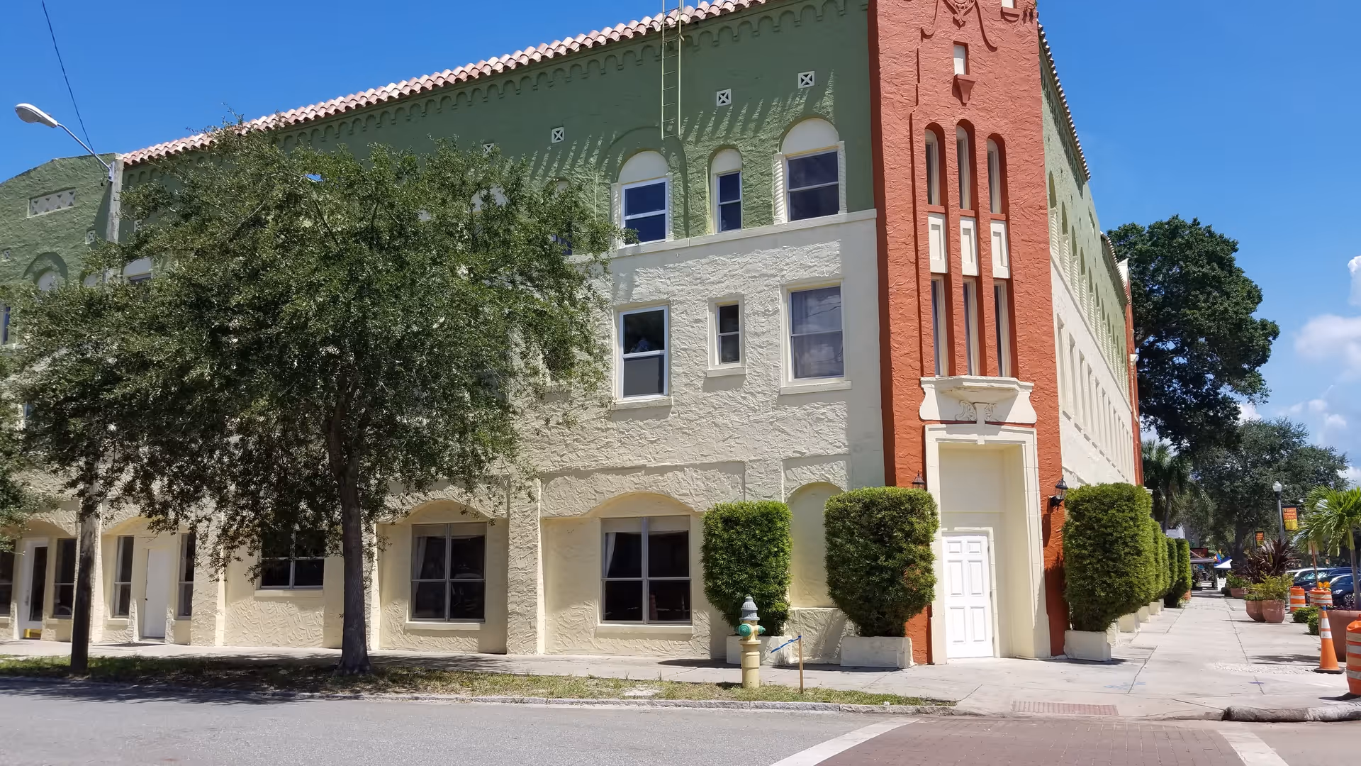 City Central Assisted Living building exterior with green walls, red column, and tree-lined sidewalk.