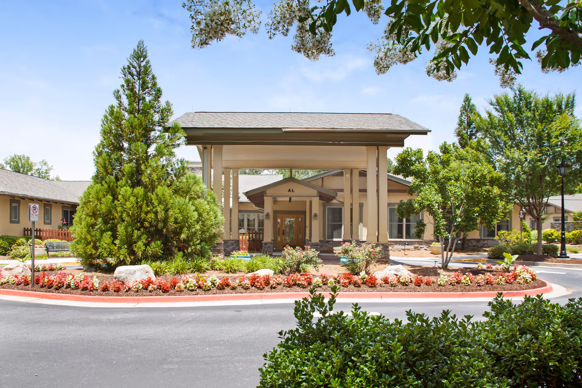 Front view of Sunrise at Webb Gin entrance with manicured landscaping and circular drive.