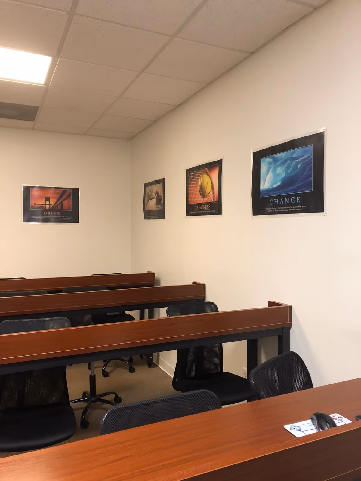A classroom-style training room in a senior living facility with long desks and posters.