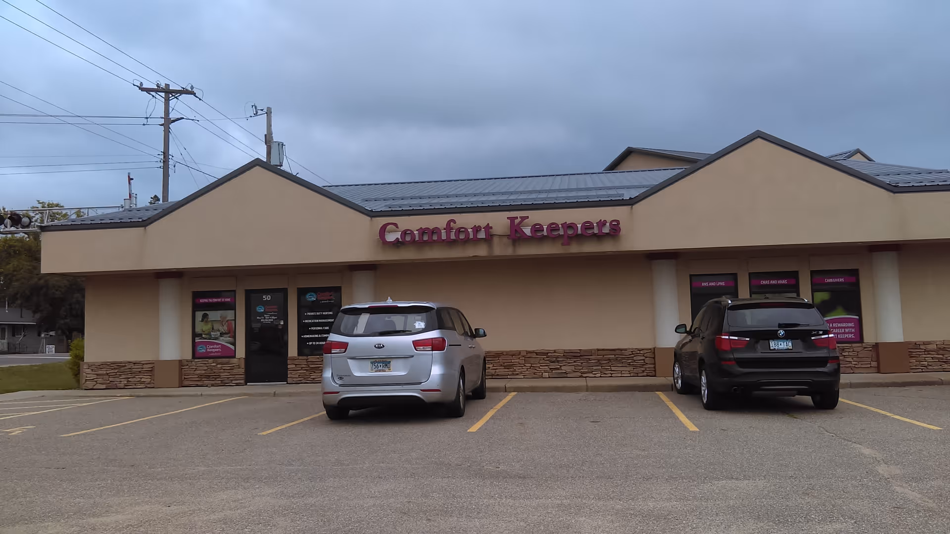 Exterior view of Comfort Keepers in-home care facility with two parked cars.