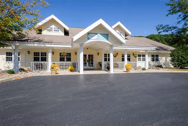 Front view of Tipton Place senior living facility with covered entry and planters.