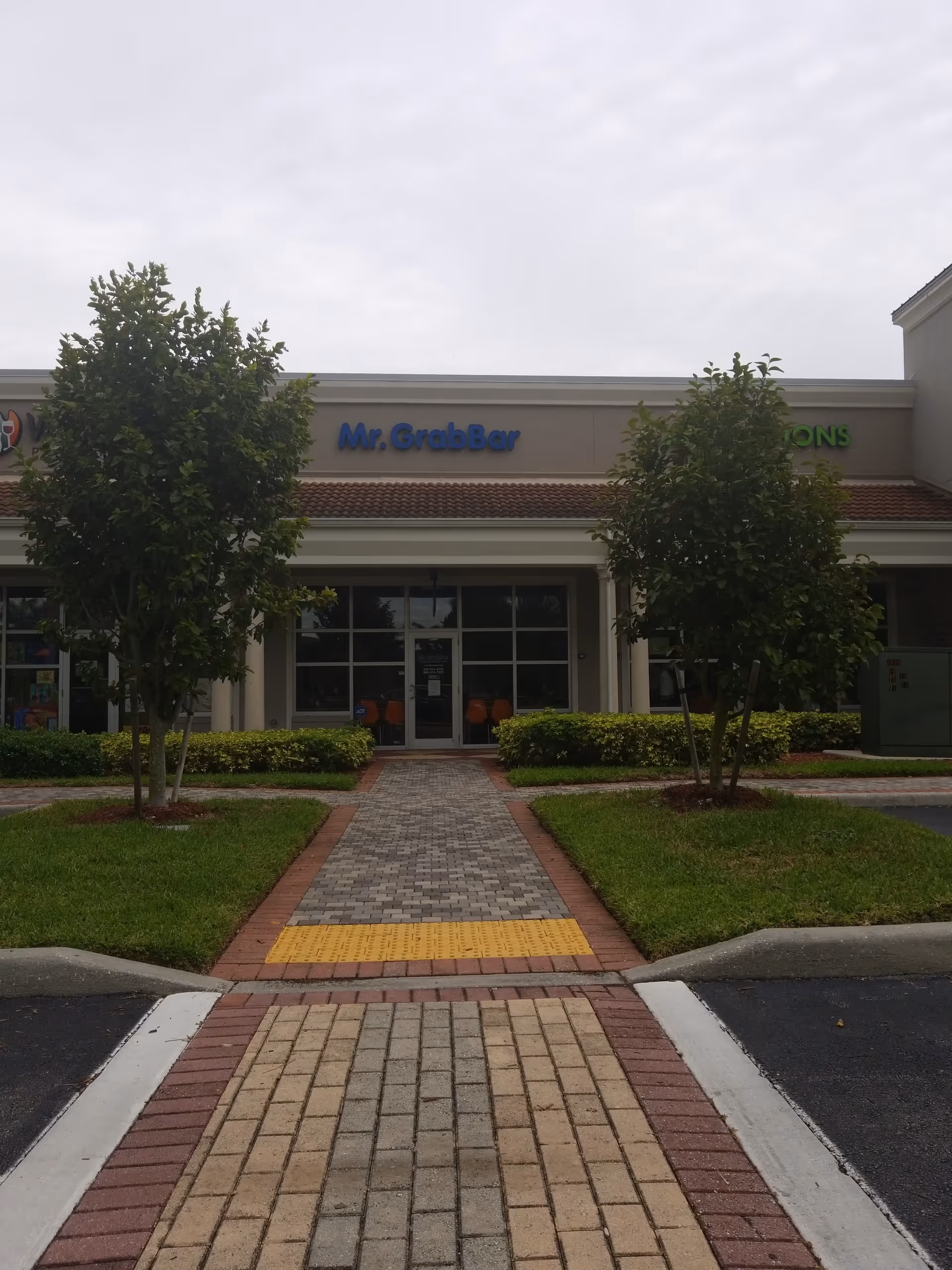 Exterior view of Mr. GrabBar facility storefront with trees and a walkway.