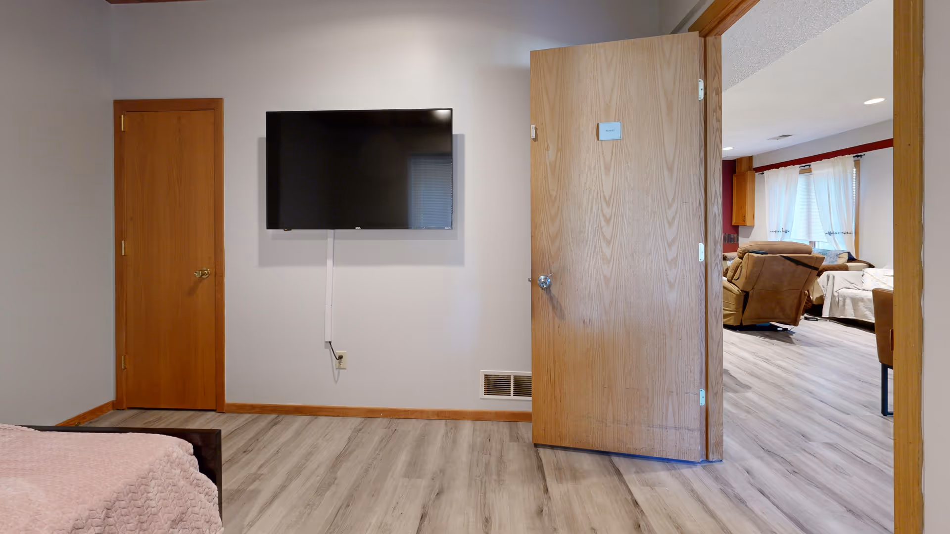 Bedroom in Maple Care Homes of Apple Valley with a wall-mounted television.