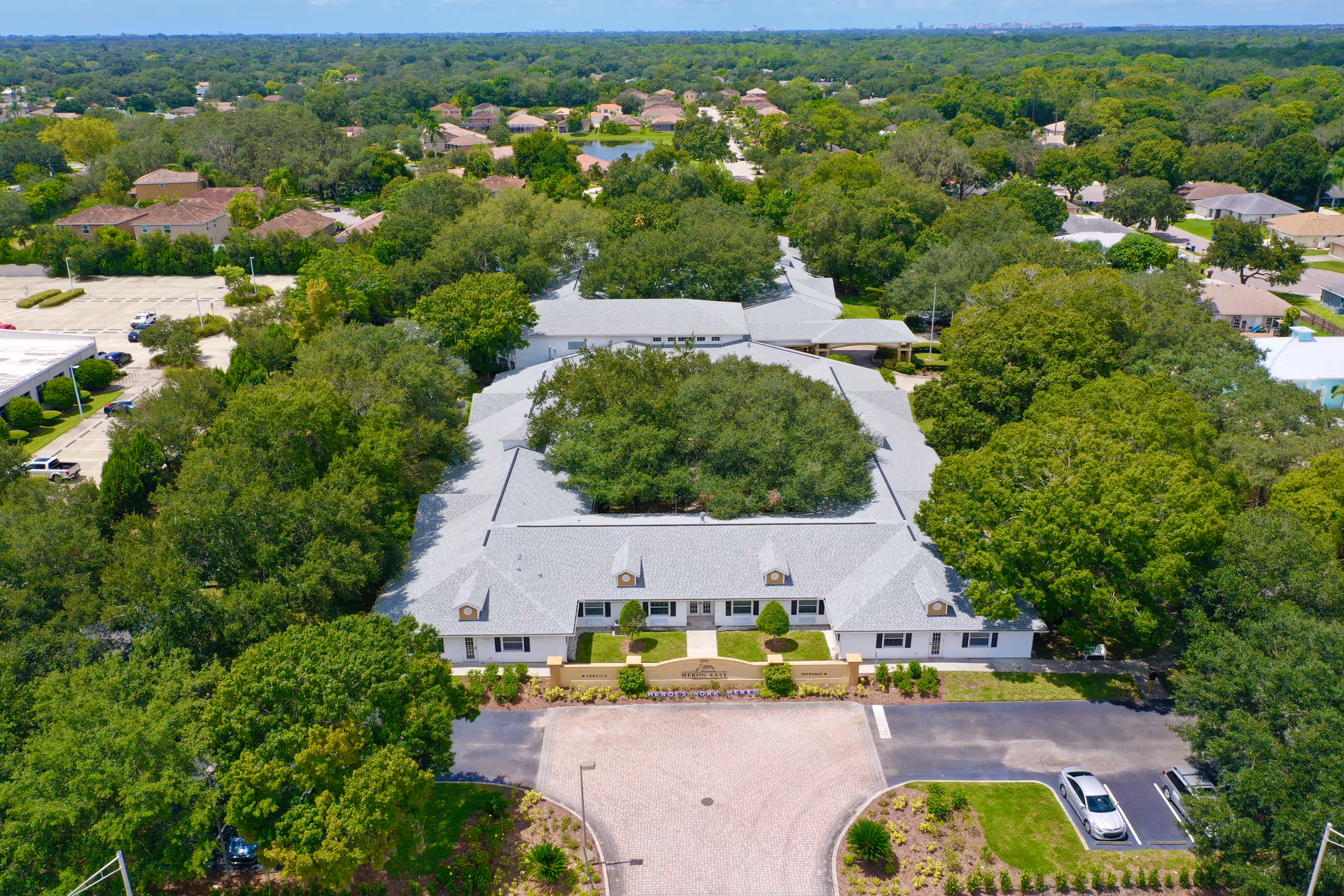Aerial view of Heron East senior living campus with a central white-roofed building.