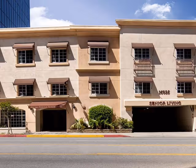 Front exterior of Encino Terrace Senior Living building with signage and entrance