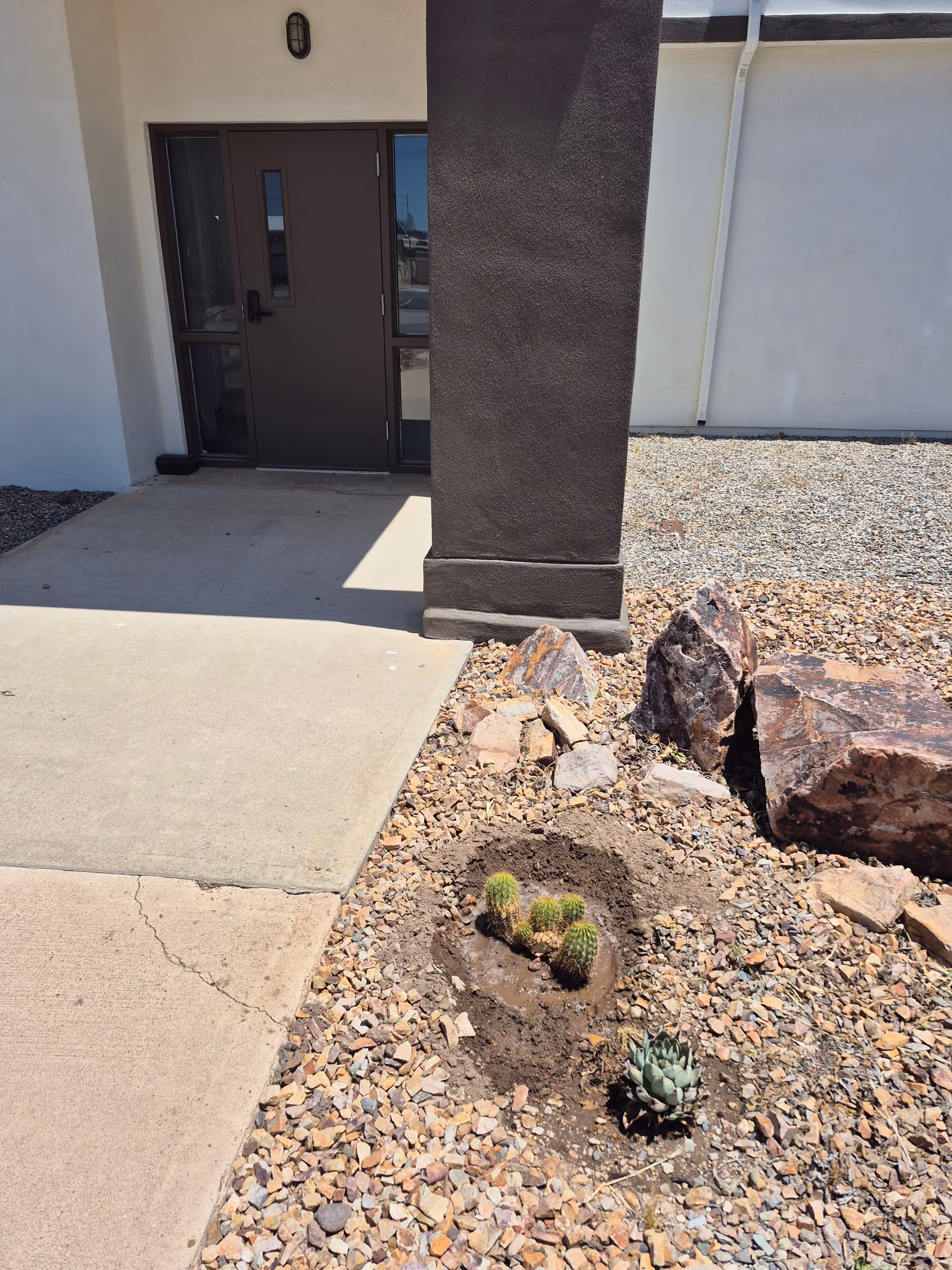 Exterior view of facility entrance with a rocky desert landscape.