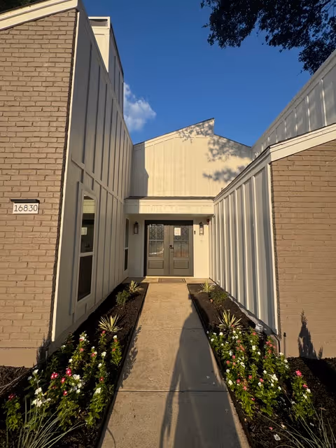 Exterior view of Evergreen Assisted Living entrance with brick walls and landscaped walkway.