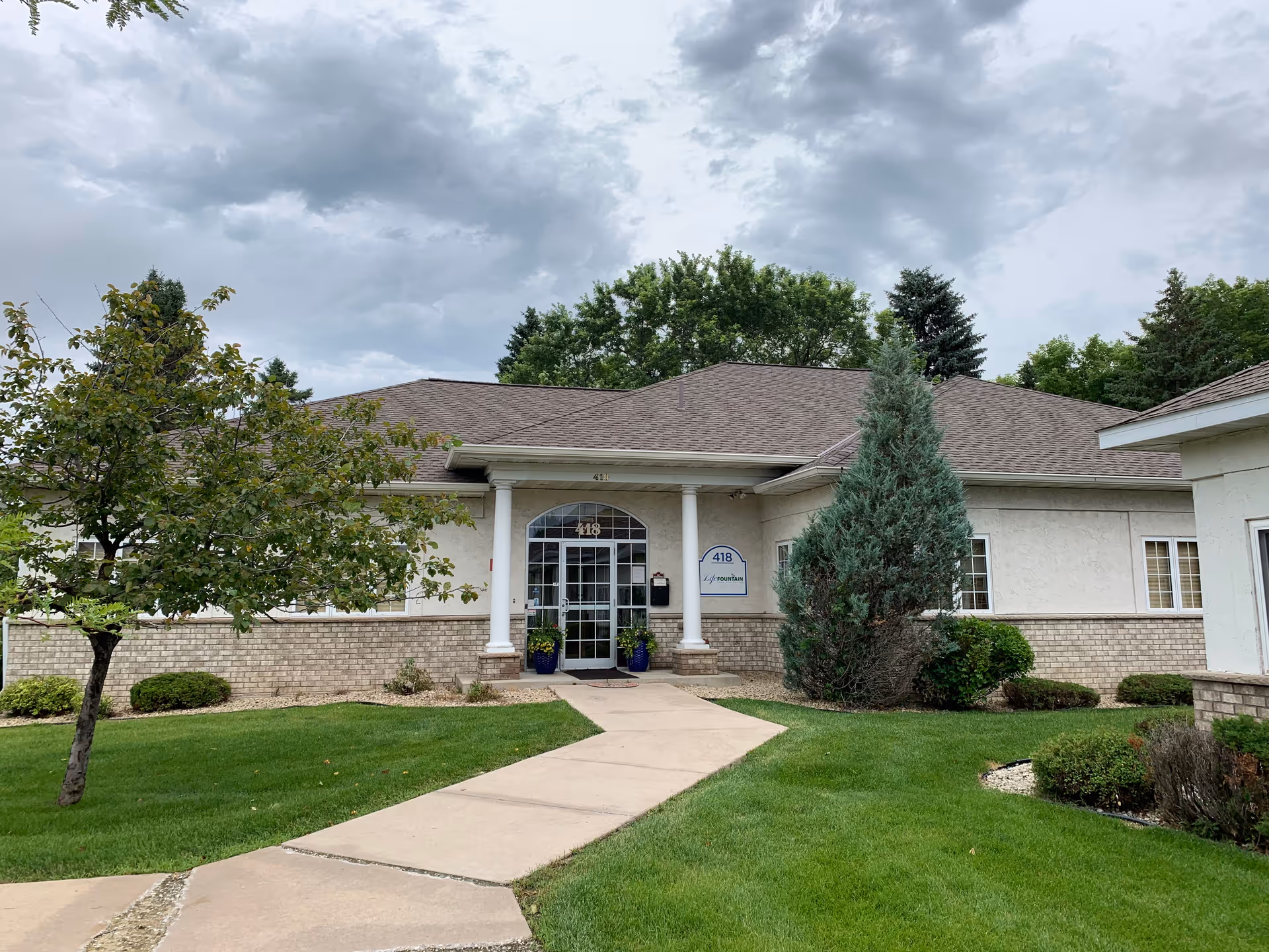 Front view of Life Fountain Home Health Care building with entrance path and landscaping.