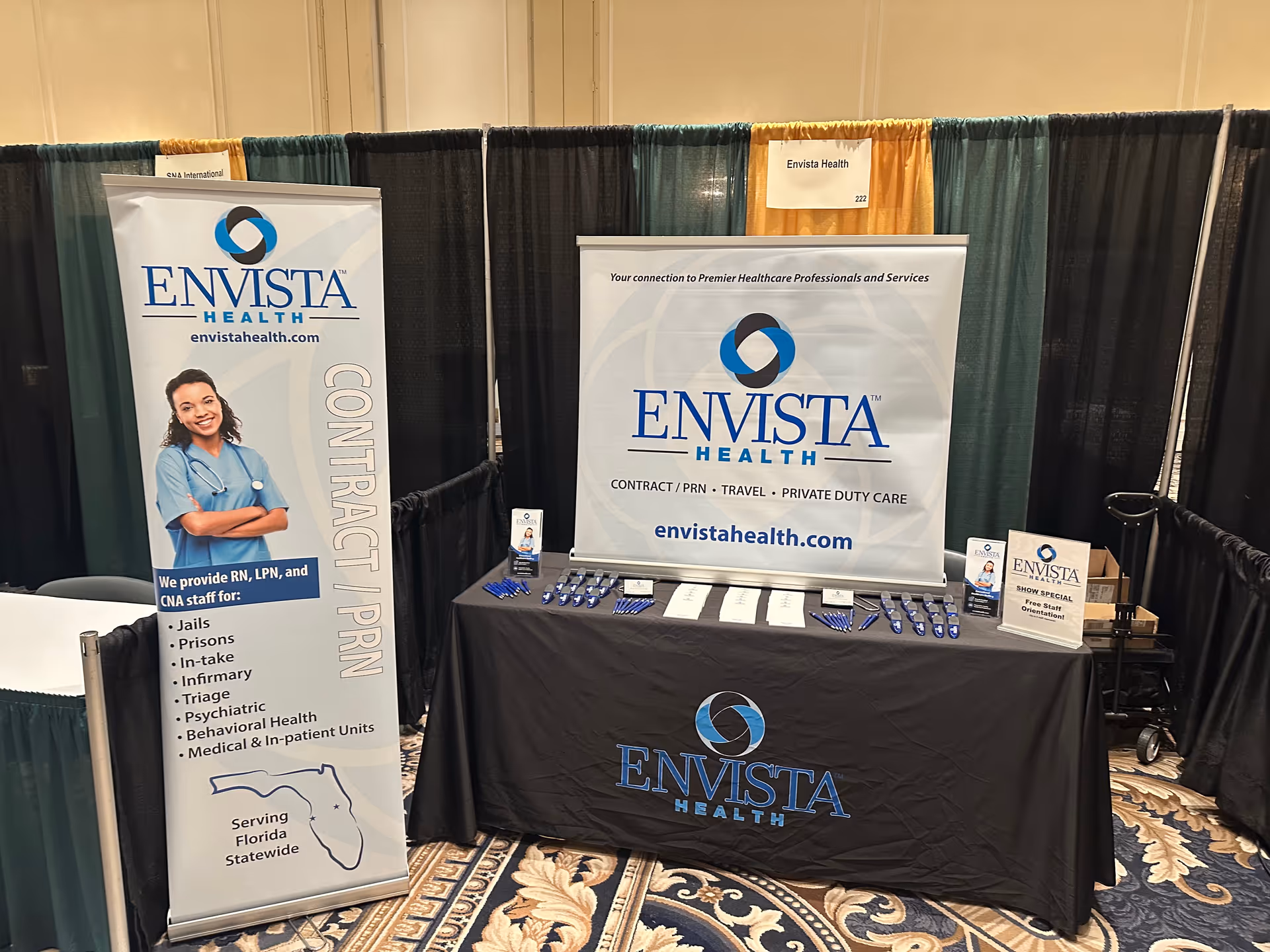 Indoor expo booth for Envista Health with banners, table, and promotional materials.