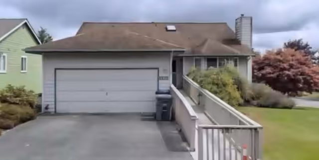 Front exterior of a single-story adult family home with attached garage and wheelchair ramp.