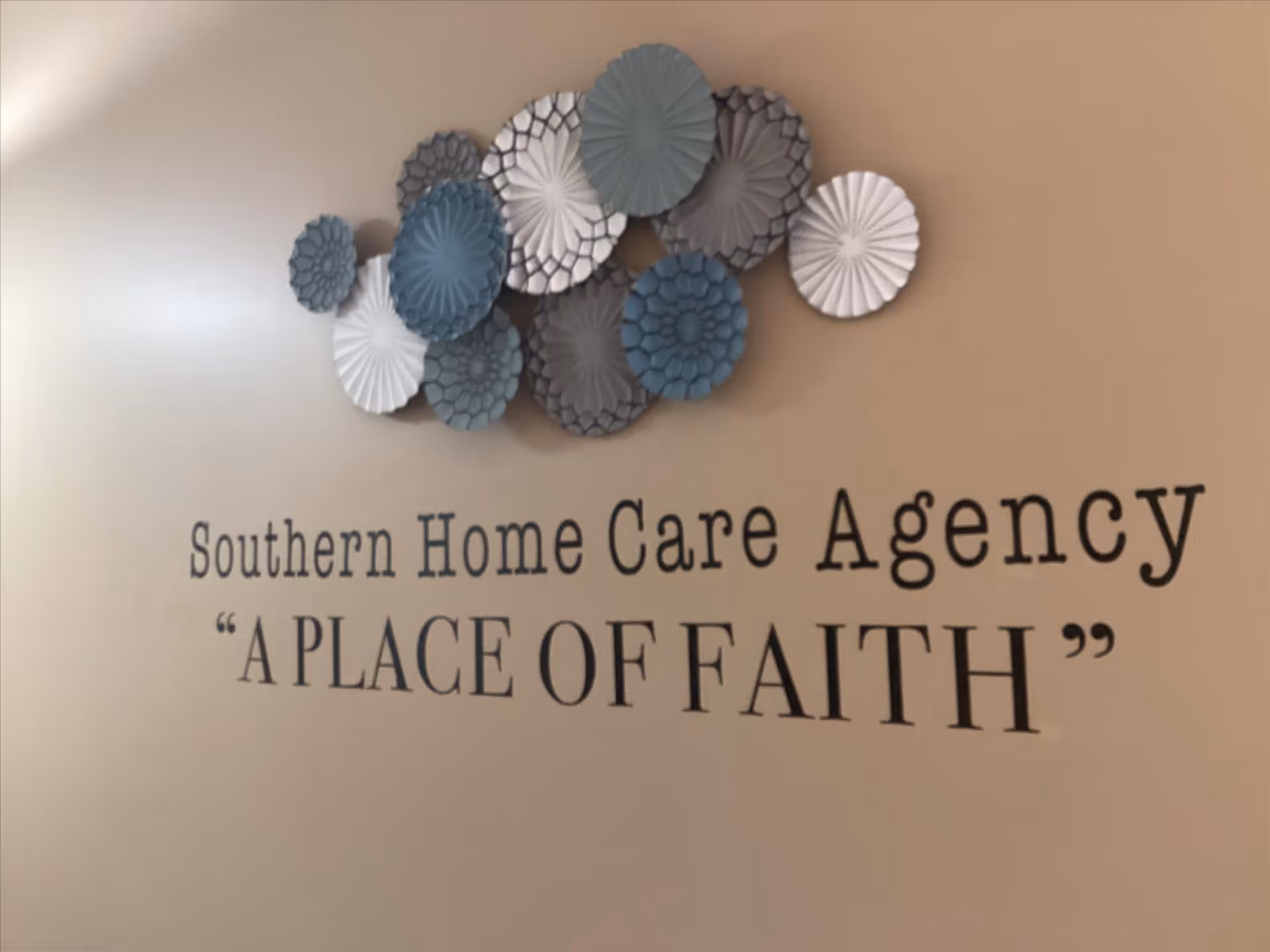 Interior wall with circular blue-grey decor and 'A PLACE OF FAITH' sign.