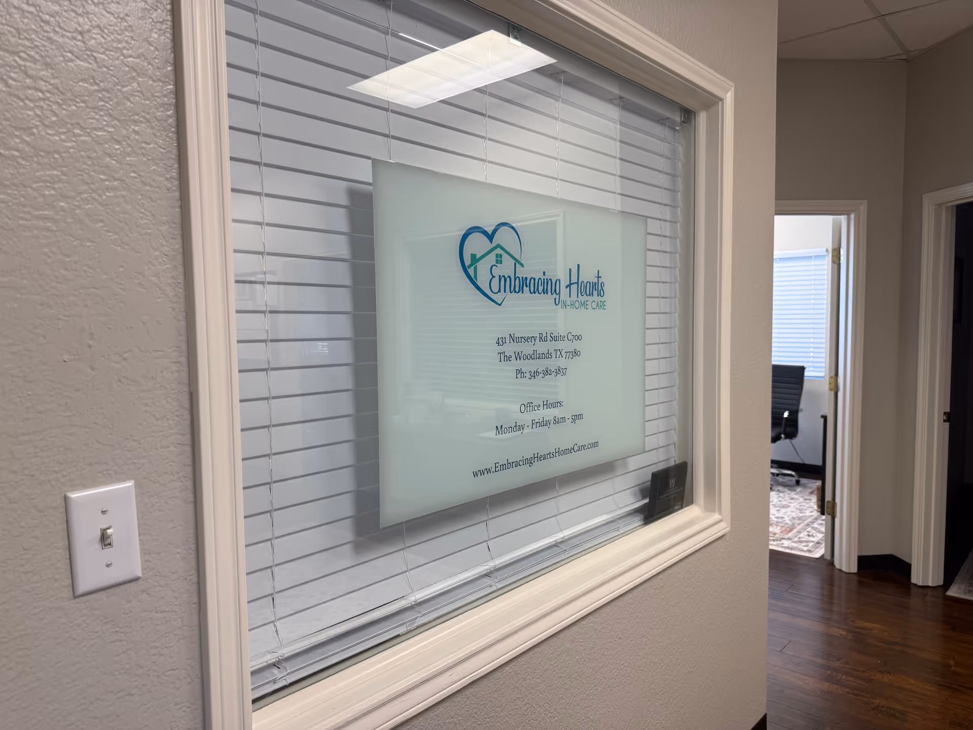 Interior office window with Embracing Hearts In-Home Care sign.