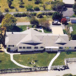 Aerial view of a single-story senior living facility with lawn and curved walkways.