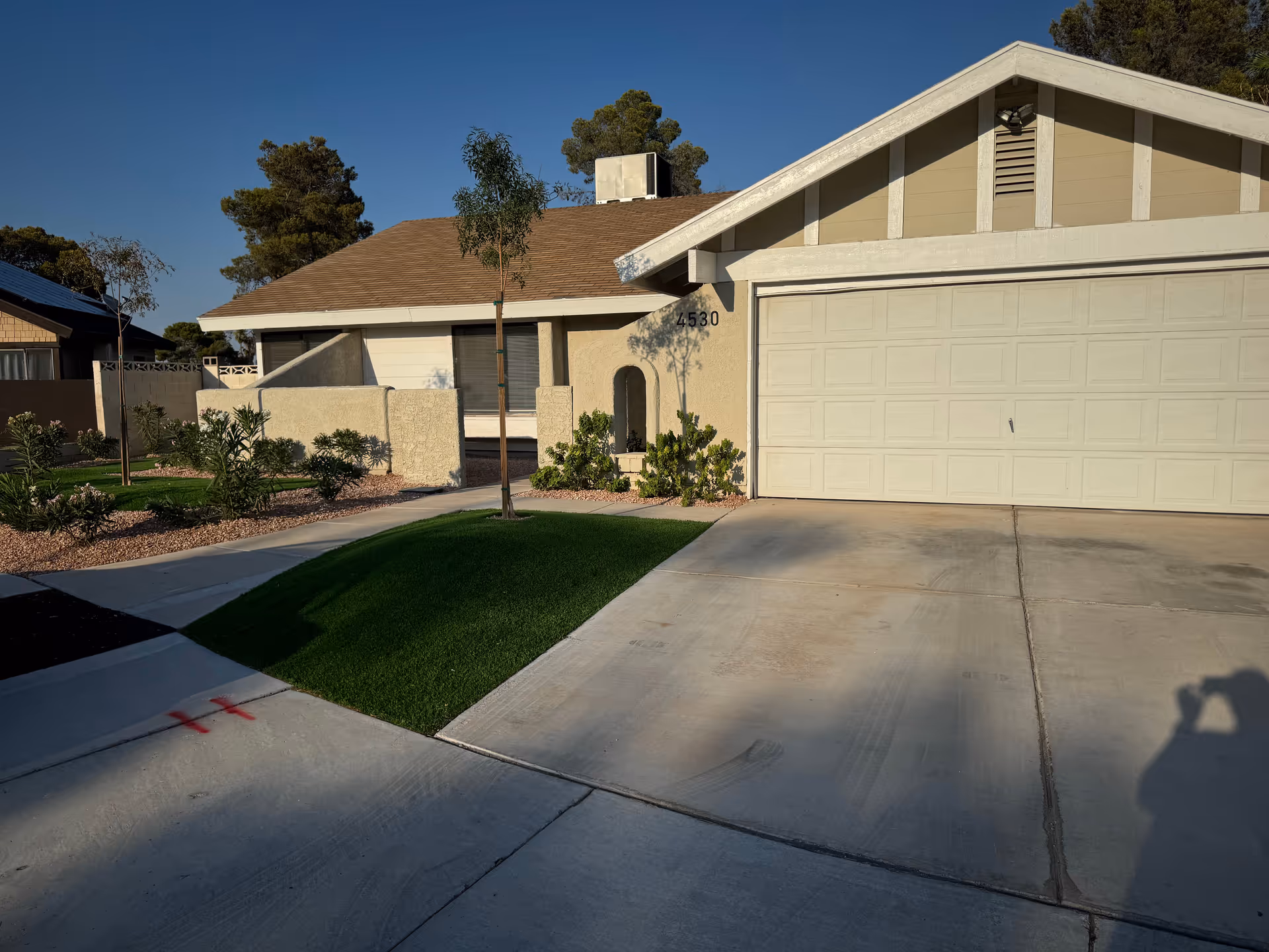 A suburban single-story home with a two-car garage and front yard landscaping.
