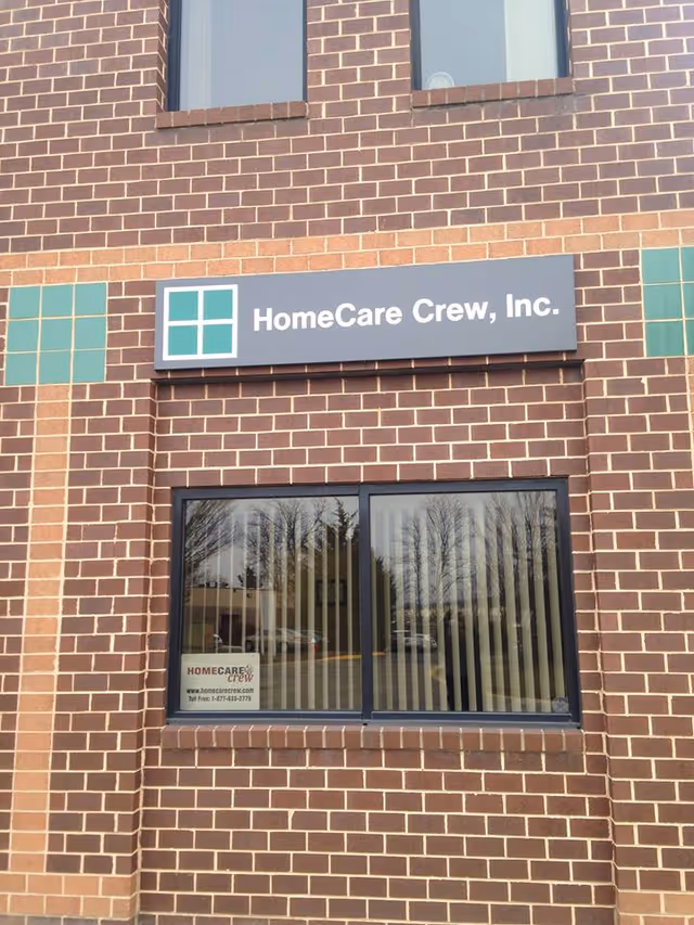 Brick building exterior with a HomeCare Crew, Inc. sign above a large window.